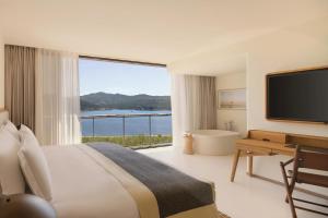 a hotel room with a large bed and a large window at Six Senses Ibiza in Portinatx