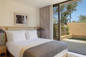 1 dormitorio con cama y ventana grande en Six Senses Ibiza, en Portinatx