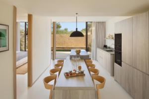 a kitchen and dining room with a table and chairs at Six Senses Ibiza in Portinatx