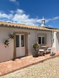 a house with a patio with a table and a building at Vila Lobo Algarve in Faro