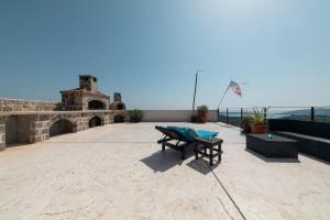 un patio con mesa y bancos en la parte superior de un edificio en Luxury Holidays & Events - Villa Diva - Montenegro, en Klinci