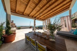un patio con mesa de madera y sillas en Luxury Holidays & Events - Villa Diva - Montenegro, en Klinci