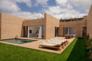 a backyard with a swimming pool and a house at Six Senses Ibiza in Portinatx