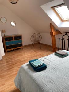 a bedroom with a bed and a dresser and a chair at Ker valyan in Cancale
