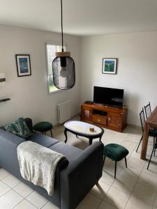 uma sala de estar com um sofá e uma mesa em Ker valyan em Cancale
