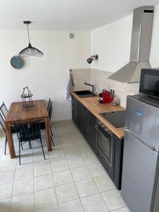 uma cozinha com uma mesa, um fogão e um frigorífico em Ker valyan em Cancale
