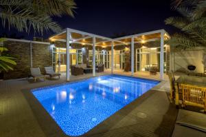 una piscina en una casa por la noche en Dar 66 Pool Chalets with Jacuzzi, en Ras al Khaimah