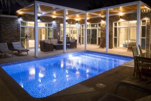 a swimming pool in the middle of a house at night at Dar 66 Pool Chalets with Jacuzzi in Ras al Khaimah