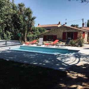 a swimming pool in front of a house at LE CLOS DE LA VINIERE in Jard-sur-Mer
