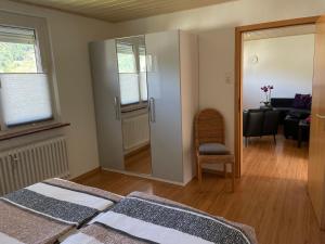 a bedroom with two beds and a chair and a desk at Ferienwohnung Dieblich an der Mosel in Dieblich