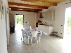 cocina con mesa y sillas en una habitación en Casa nell'agrumeto con piscina, en Pozzallo