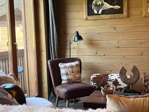 ein Wohnzimmer mit einem Stuhl und einem Foto eines Hundes in der Unterkunft Instant Méribel in Les Allues