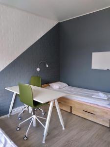 a desk and a chair in a room with a bed at Harju Apartments in Jyväskylä