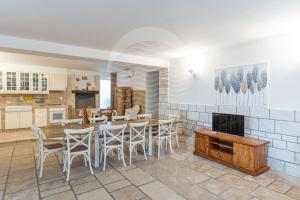 una cucina e una sala da pranzo con tavolo e sedie di Villa Incanto-Piano Terra - Fronte mare a Porto Cesareo