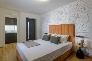 a bedroom with a large bed with a black and white wall at Meno Suite with Private Terrace - Jaccuzzi, Acropolis View in Athens +30 photos