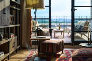 een kamer met een stoel, een tafel en een balkon bij FREIgeist Göttingen Nordstadt, A Member of Design Hotels in Göttingen