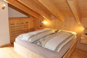 a bedroom with a bed in a room with wooden ceilings at Bike&Ski Centro Apartments in Livigno