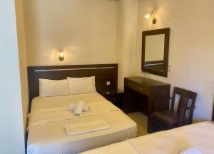 een slaapkamer met een bed met een spiegel en een bureau bij Hotel Alkionis in Ierissos