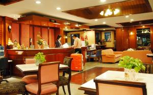 a restaurant with people standing at the bar at Silom Village Inn in Bangkok