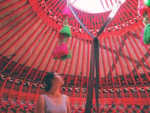 a woman is standing under a red umbrella at SilkRoad Guesthouse in Bishkek