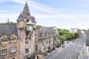 an old building with a clock on it on a street at ALTIDO Cosy flat in the heart of Edinburgh in Edinburgh