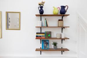 a shelf on a wall with books at ALTIDO Cosy flat in the heart of Edinburgh in Edinburgh