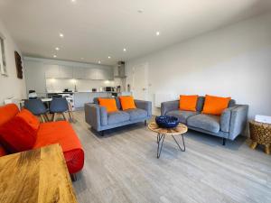 a living room with two couches and a table at 3 Putsborough - Luxury Apartment at Byron Woolacombe, only 4 minute walk to Woolacombe Beach! in Woolacombe