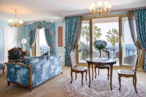 a living room filled with furniture and a large window at Hotel Le Negresco in Nice