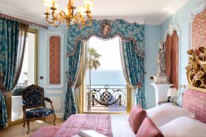 a bedroom with a bed and a view of the ocean at Hotel Le Negresco in Nice