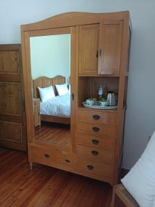 a wooden cabinet with a mirror in a bedroom at Fondazione Lucia De Conz 