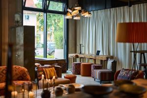 a living room filled with furniture and a table at FREIgeist Göttingen Nordstadt, A Member of Design Hotels in Göttingen