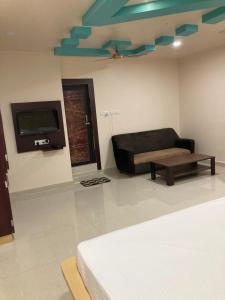 a living room with a couch and a tv at Hotel City View in Bhubaneshwar