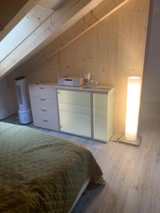 Dormitorio con cama y escritorio en el ático en Tolles Loft in den Tessiner Bergen en Corcapolo