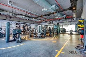 a gym with cardio equipment and a wall with a mural at Airy Studio in Studio One Dubai Marina by Deluxe Holiday Homes in Dubai