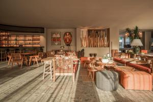 a living room with tables and chairs and a dining room at Cook's Club Corfu - Adults Only in Gouvia