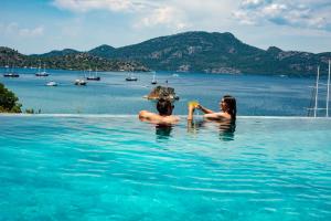 dos personas en el agua en una piscina en Alice Tatil Evi, en Marmaris