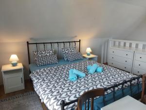 een slaapkamer met een groot bed met blauwe kussens bij Spaletta in Pécsely