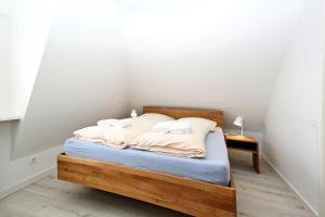 a bedroom with a bed with a wooden frame at Senhues-App-7 in Hörnum