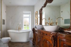 a bathroom with two sinks and a tub and a toilet at Plas Dinas Country House in Caernarfon