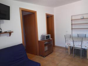 a living room with a table and a microwave at AltaMarea in Stintino