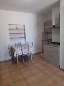 cocina con mesa y sillas en una habitación en AltaMarea, en Stintino