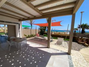 a patio with a table and chairs and an umbrella at Arabel Villas in Reitani