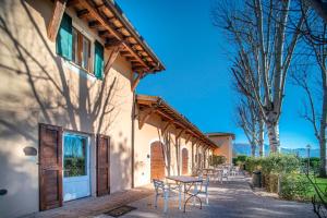 a patio with a table and chairs next to a building at Hotel Villaggio Le Stelline in Montefalco