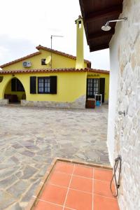 una casa amarilla con un patio de ladrillo delante de ella en villa Letizia, en Pula