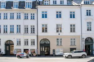two cars parked in front of a building at The Churchill Penthouse by Daniel&Jacob's in Copenhagen