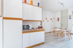 a kitchen with white cabinets and a table at Crocetta Family Apartment by Wonderful Italy in Turin