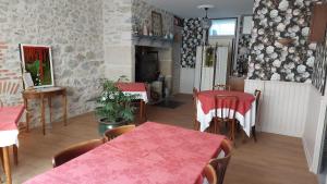 a dining room with two tables and a fireplace at Auberge de la Tradition in Corrèze