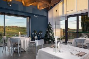 ヴィンチにあるGolf Club Bellosguardo resortの白いテーブルと椅子、クリスマスツリーのあるレストラン