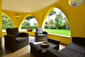 sala de estar con paredes y sillas de color amarillo y mesa en villa Letizia en Pula