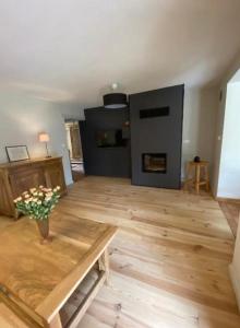 salon z kominkiem i drewnianą podłogą w obiekcie Maison avec vue imprenable w mieście Millau